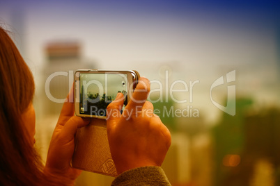 Woman taking city picture with her smartphone