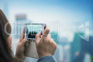 Woman taking city picture with her smartphone