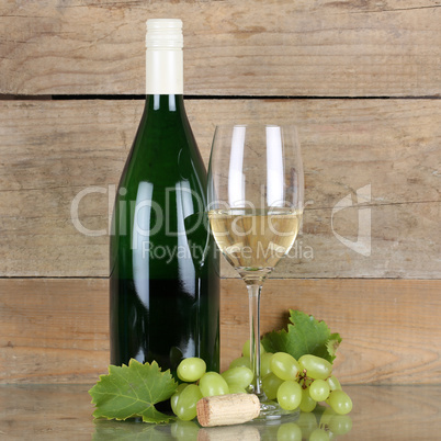 Weißwein in Flasche und Weinglas vor Holz