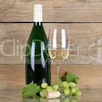 Weißwein in Flasche und Weinglas vor Holz