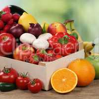 Früchte und Gemüse wie Orangen, Tomaten und Äpfel in Kiste