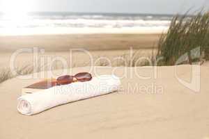 Book sunglasses  towel on a beach