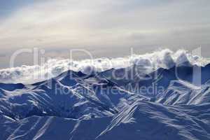 Snowy mountains in mist at winter evening