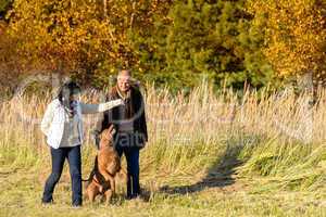 Couple playing with dog autumn sunny countryside