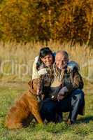 Cheerful couple with dog in autumn park