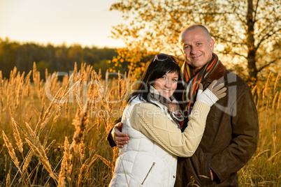Couple embracing in autumn countryside sunset