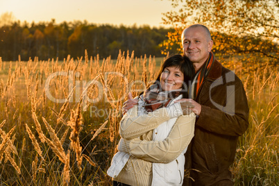 Romantic couple hugging in countryside autumn sunset