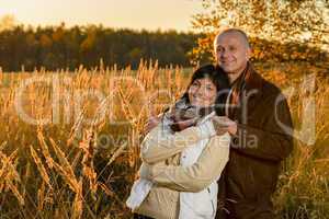 Romantic couple hugging in countryside autumn sunset