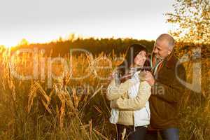 Couple hugging during autumn sunset countryside