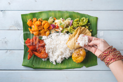Indian woman eating banana leaf rice