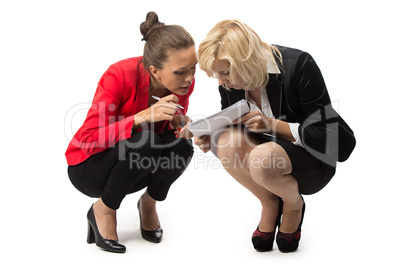 Two businesswoman sitting with sheet of paper