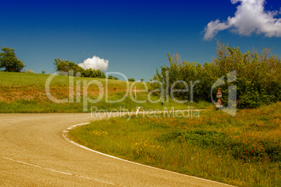 Road through Tuscany meadows and hills - Italy