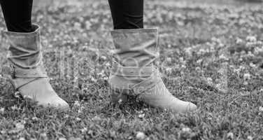 Woman boots on a green garden