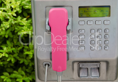 Silver public telephone with pink terminal