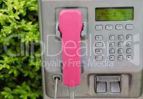 Silver public telephone with pink terminal