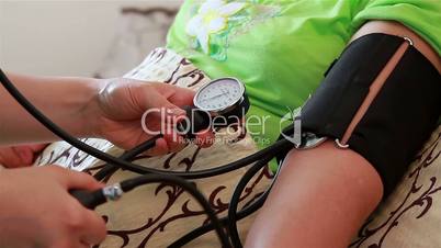 Blood pressure check to senior woman. Close up.