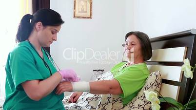 Nurse bandaging the wrist of senior woman