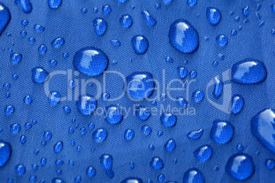 Closeup of rain drops on a blue umbrella