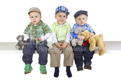 Three sitting boys with toys