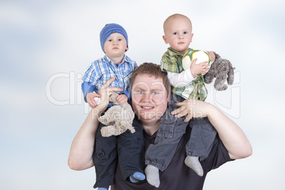 Father carrying his twin children on shoulders