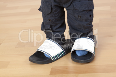 Children's feet in large slippers