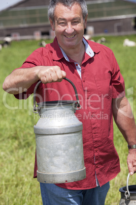 farmer with milk churns at his cows