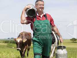 Farmer with milk jug with the cows