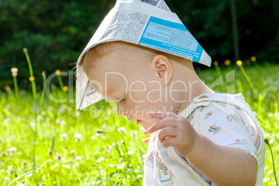 Baby with Paper on the summer meadow