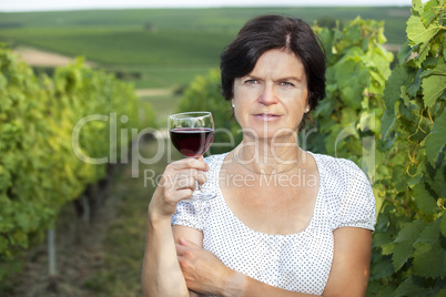 Woman in vineyard holding wine glass