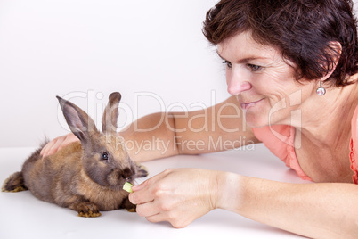 Young woman feeding rabbits