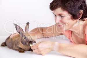 Young woman feeding rabbits
