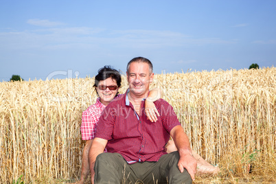 Woman and man sitting on the wheat field