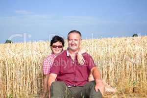 Woman and man sitting on the wheat field