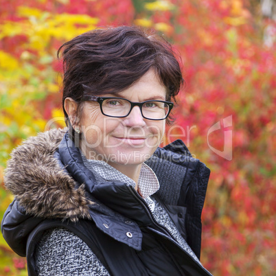 Woman in front of autumnal flowering bush