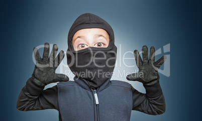 Surprised comic burglar stopped and take his hands up