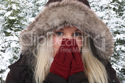 Junge Frau im Winter beim Frieren in der Kälte im Wald