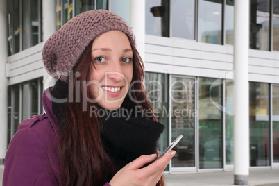 Junge Frau beim Telefonieren mit Smartphone oder Handy draußen