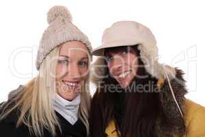 Zwei lachende Frauen im Winter mit Mütze und Schal