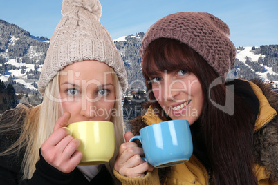 Junge Frauen beim Trinken einer Tasse Tee draußen in den Bergen