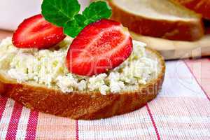 Bread with curd and strawberries on red fabric