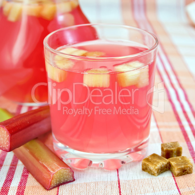 Compote from rhubarb in glass and pitcher on tablecloth