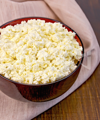 Curd in wooden bowl with napkin on board