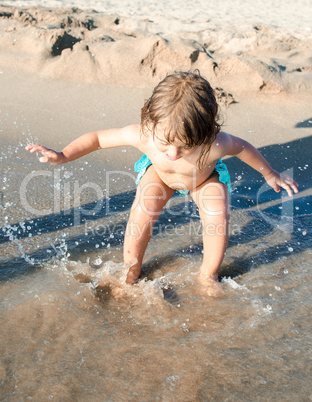 Baby playing with sea water at the beach