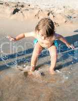 Baby playing with sea water at the beach