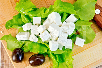 Feta with green lettuce and black olives on board