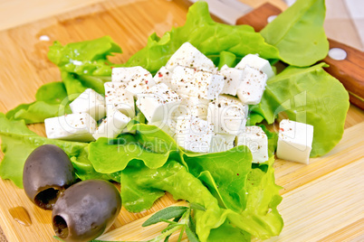 Feta with lettuce and black olives on board