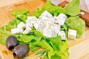 Feta with lettuce and black olives on board