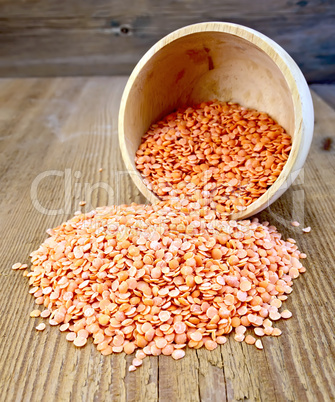 Lentils red in wooden bowl on the board