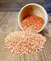 Lentils red in wooden bowl on the board