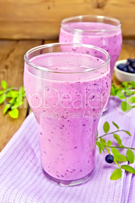 Milkshake with blueberries in glasses on board